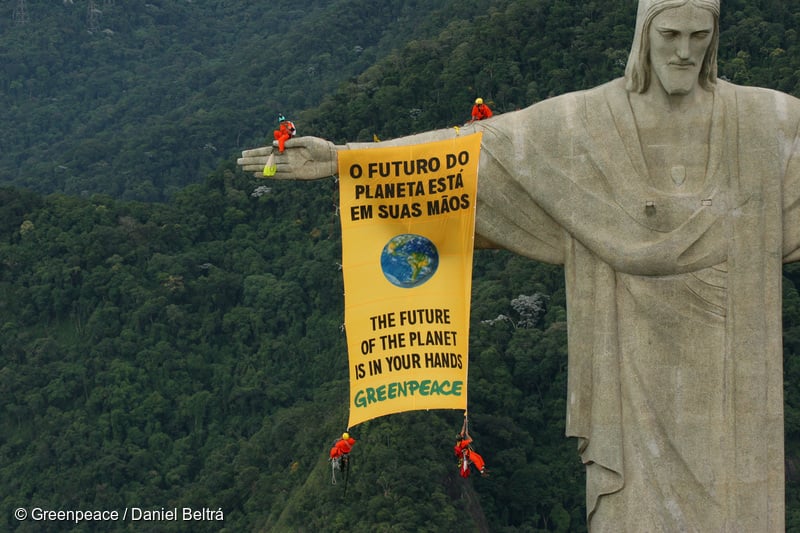 Foto de ação com faixa na estátua do Cristo Redentor no Rio de Janeiro